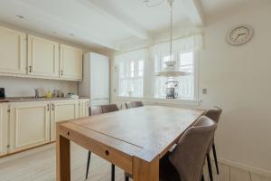 a kitchen with a wooden table and chairs at Jógvansstova - 2BR House - Explore the North in Leirvík