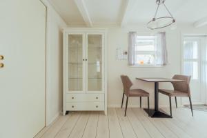 a dining room with a table and chairs and a cabinet at Jógvansstova - 2BR House - Explore the North in Leirvík +16 photos