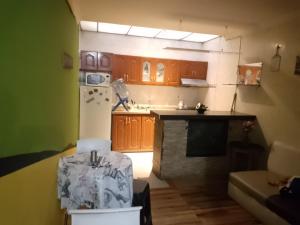 a kitchen with wooden cabinets and a white refrigerator at hospedaje dorado engativá in Bogotá
