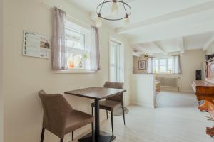 a kitchen and dining room with a table and chairs at Jógvansstova - 2BR House - Explore the North in Leirvík