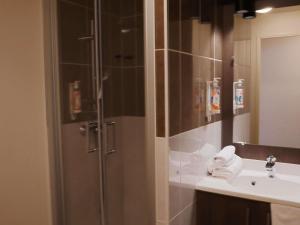 a bathroom with a shower and a sink at Aparthotel Adagio Access Poitiers in Poitiers