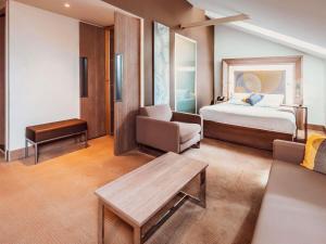 a hotel room with a bed and a couch at Novotel Toulouse Centre Wilson in Toulouse +131 photos
