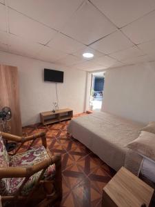 a bedroom with a bed and a flat screen tv at Alojamiento Mujer Dormida in Ambuquí