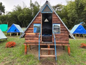 a cabin with three tents in a field at Camping El Paraiso in Calima