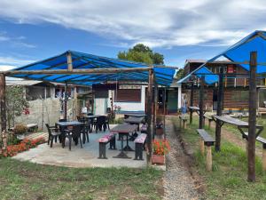a picnic shelter with tables and benches in a yard at Camping El Paraiso in Calima