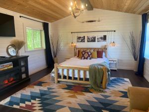 a bedroom with a bed and a tv and a fireplace at Willow Pond Cabin in Ellensburg