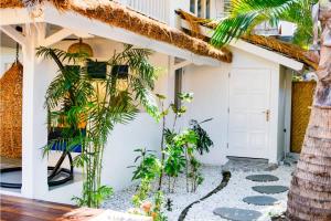 a house with plants in the front yard at Villa Asmara Gili Air in Gili Islands