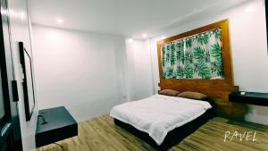 a bedroom with a bed and a window with palm trees at PNS BORACAY Station 1 in Boracay
