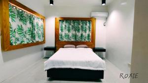a bedroom with a bed and a window with curtains at PNS BORACAY Station 1 in Boracay