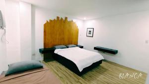 a bedroom with a bed with a wooden head board at PNS BORACAY Station 1 in Boracay