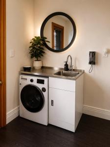 a bathroom with a washing machine and a sink at Lake Brunner Chalet in Moana