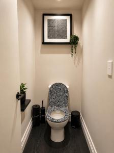 a bathroom with a toilet with a black and white seat at Lake Brunner Chalet in Moana
