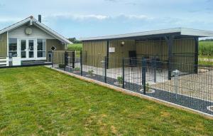 a building with a fence in front of a yard at 3 Bedroom Amazing Home In Haderslev in Haderslev