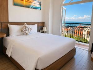 a bedroom with a large bed and a large window at Anna seaview hotel in Phú Quốc
