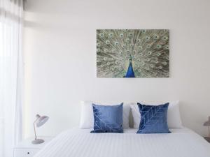 a bedroom with a bed with a peacock painting on the wall at The Sebel Launceston in Launceston +84 photos