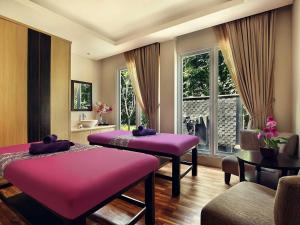 two purple beds in a room with a window at Grand Mercure Bandung Setiabudi in Bandung
