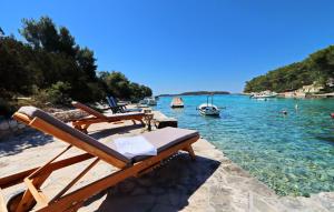 a beach with chairs and boats in the water at Villa Beachfront Korcula in Vela Luka +42 photos