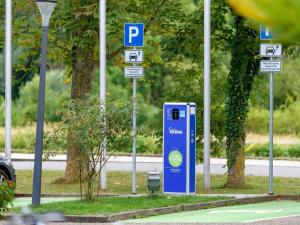 a blue parking meter next to a street with street signs at Ibis Styles Regensburg in Regensburg