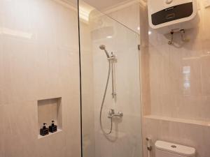 a bathroom with a shower with a glass door at Hotel Butik Sawunggaling in Bandung +14 photos
