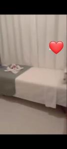 a red heart pinned to a wall next to a bed at Apartamento térreo com 3 quartos no Tree Bies- próximo do parque aquático infantil in Subaúma