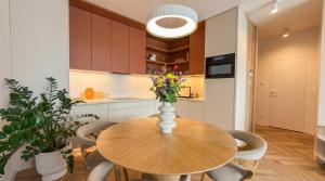 a kitchen with a wooden table with chairs and a vase with flowers at Bela Bonita in Spišská Belá +3 photos