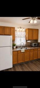 a kitchen with wooden cabinets and a white refrigerator at The sunflower stay in Garden City