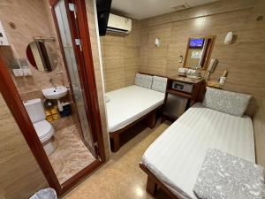 a small room with two beds and a sink at Sleep Inn in Hong Kong +66 photos