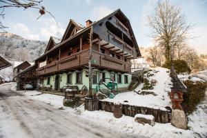 a house on a snow covered street in front at Apartments Sodja in Bohinj