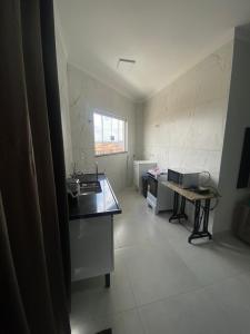 a kitchen with a sink and a table in it at loft espaço inteiro 1 quarto c/ ar condicionado in Indaiatuba