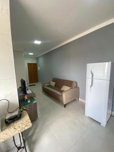 a living room with a couch and a refrigerator at loft espaço inteiro 1 quarto c/ ar condicionado in Indaiatuba +3 photos