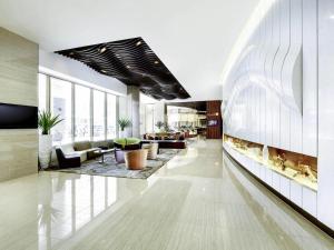 a lobby with couches and tables in a building at Novotel Ambassador Suwon in Suwon