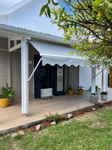 a house with a porch with a blue door at Villa Odeyssia in Sainte-Anne