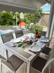 a white table with plates and flowers on it at Villa Odeyssia in Sainte-Anne