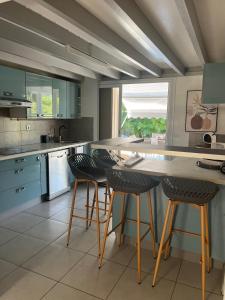 a kitchen with a large counter with bar stools at Villa Odeyssia in Sainte-Anne
