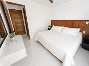 a bedroom with a white bed with a wooden headboard at Lucmar Jardín boutique in Cuernavaca +31 photos