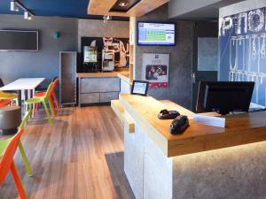 a restaurant with a desk with a video game controller on it at ibis budget Clermont Ferrand Sud in Aubière