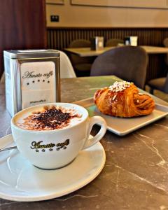a cup of coffee and a pastry on a table at Domus Alma Pompei in Pompei