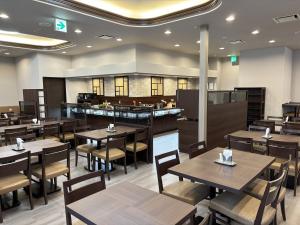 a restaurant with wooden tables and chairs and a bar at Hotel Route-Inn Tokuyama Ekimae in Shunan