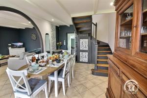 a dining room with a table and chairs and a staircase at Kerlic in Ploubazlanec