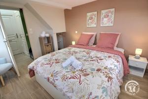 a bedroom with a large bed with pink pillows at Kerlic in Ploubazlanec