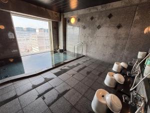 a bathroom with a shower and a swimming pool at Hotel Route-Inn Tokuyama Ekimae in Shunan
