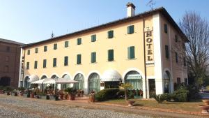 - un grand bâtiment blanc avec un panneau dans l'établissement Hotel Bentivoglio Residenza D'Epoca, à Bentivoglio