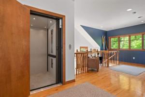a living room with a sliding glass door and a staircase at Bluff Haven by Simple Life Rentals in Fish Creek