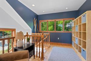 a home office with blue walls and wooden shelves at Bluff Haven by Simple Life Rentals in Fish Creek +43 photos