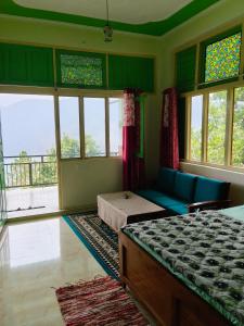 a bedroom with a bed and a couch and windows at The Moon Light Home stay in Bhīm Tāl +121 photos