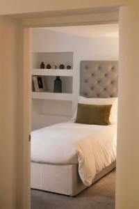 a bedroom with a white bed with a blue headboard at The Greyfriars Apartment in St. Andrews