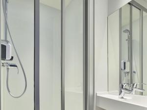 a bathroom with a shower and a sink and a mirror at hotelF1 Paris Saint Denis Stade in Saint-Denis