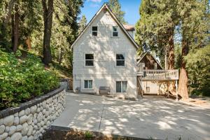 a large white house with a stone wall at SPSL Lake Arrowhead llc in Lake Arrowhead