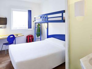 a bedroom with a white bed and a desk with a red backpack at ibis budget Curitiba Centro in Curitiba +92 photos