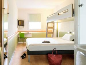 a hotel room with a bed and a sink at Ibis Budget Dole-Choisey in Dole